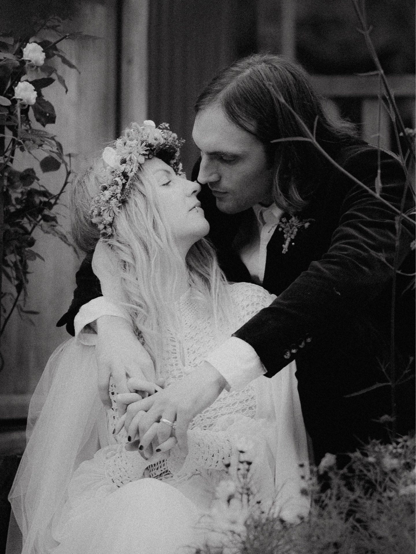 A monochrome wedding photograph capturing the embrace of a bride and groom.